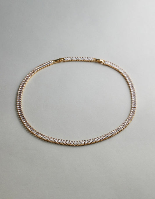 Gold Tennis Necklace on a light gray background