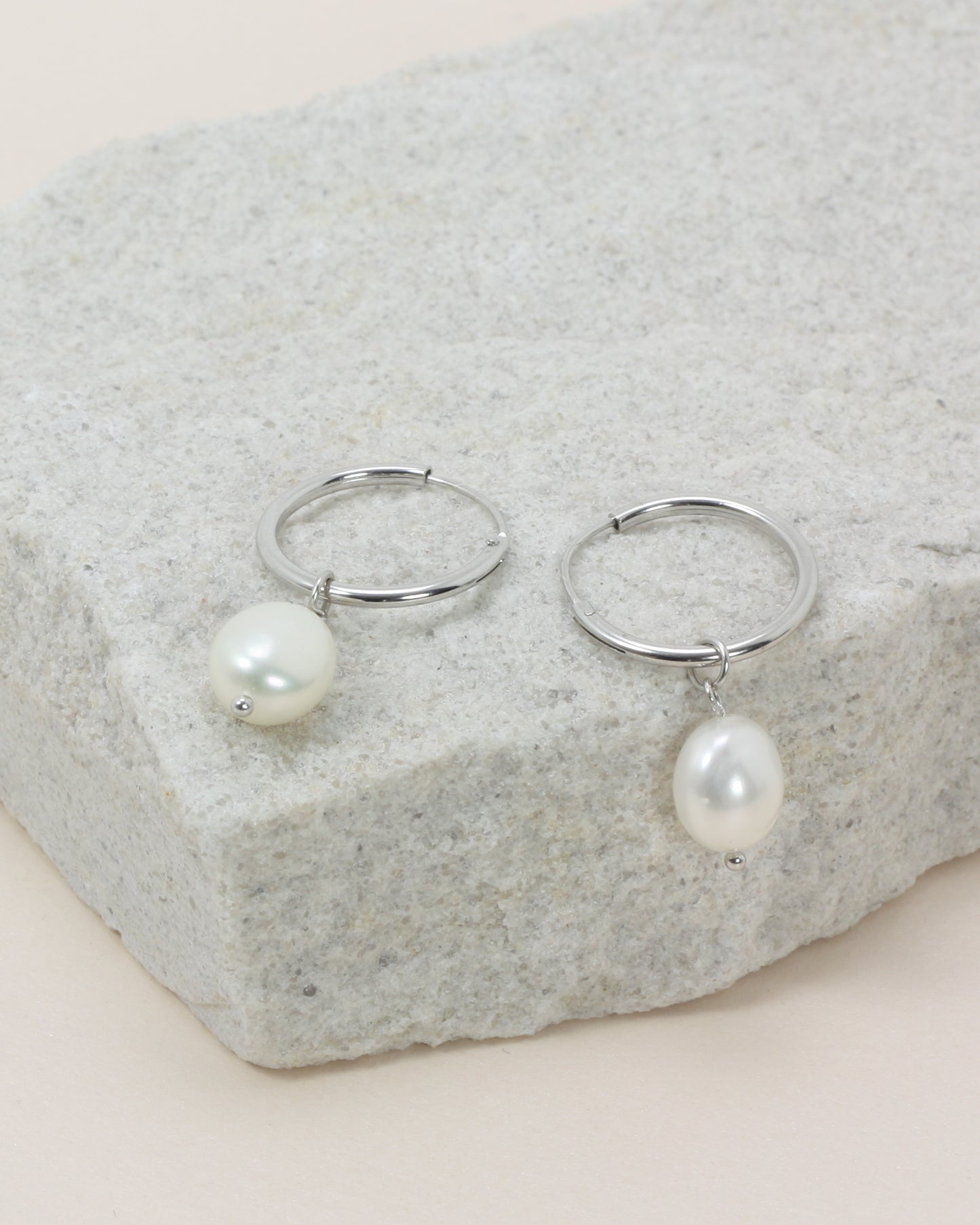 Oakley Pearl Hoops - Silver close up flat lay