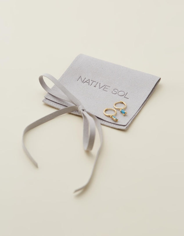 Rita Huggies - Turquiose & Gold earrings laid out on grey jewellery pouch