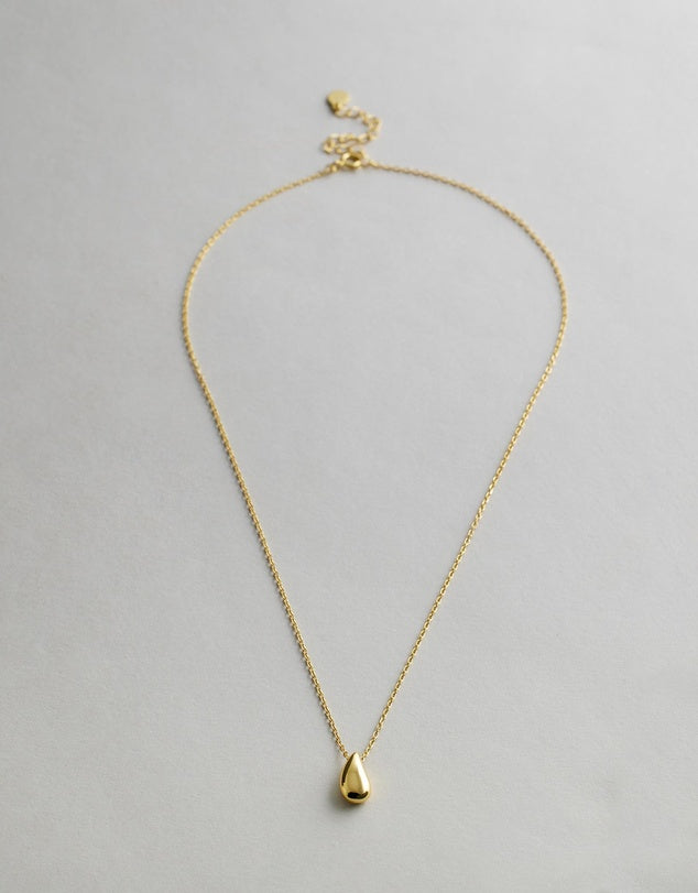 Gold Capri Teardrop Necklace with a teardrop pendant on a light gray background