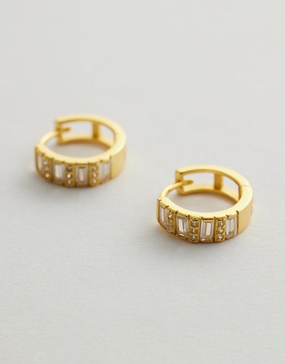 Elysia Diamond Huggie Earrings with embedded stones on a light gray background