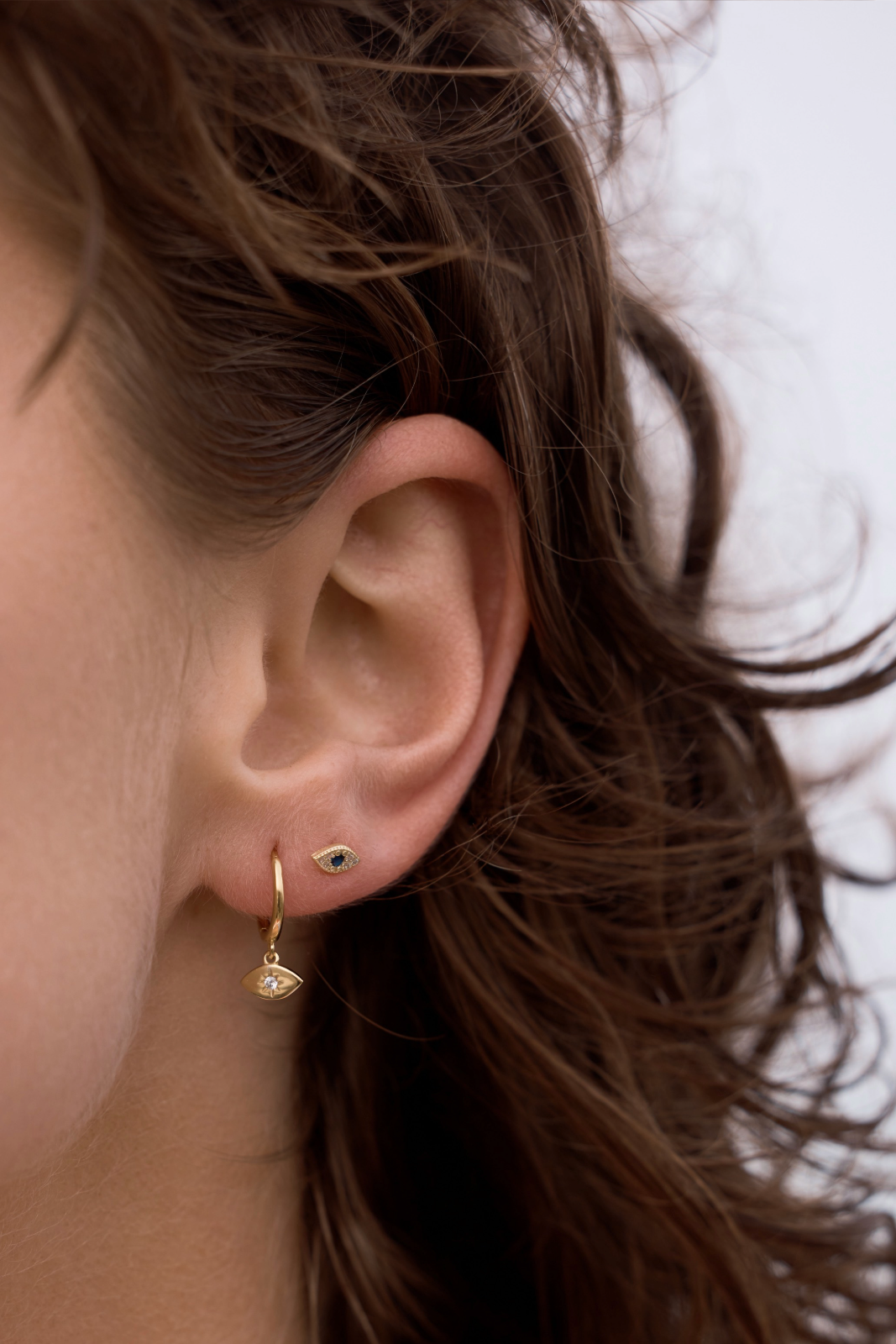 Close-up of Evil Eye Studs - Gold on a womens ear