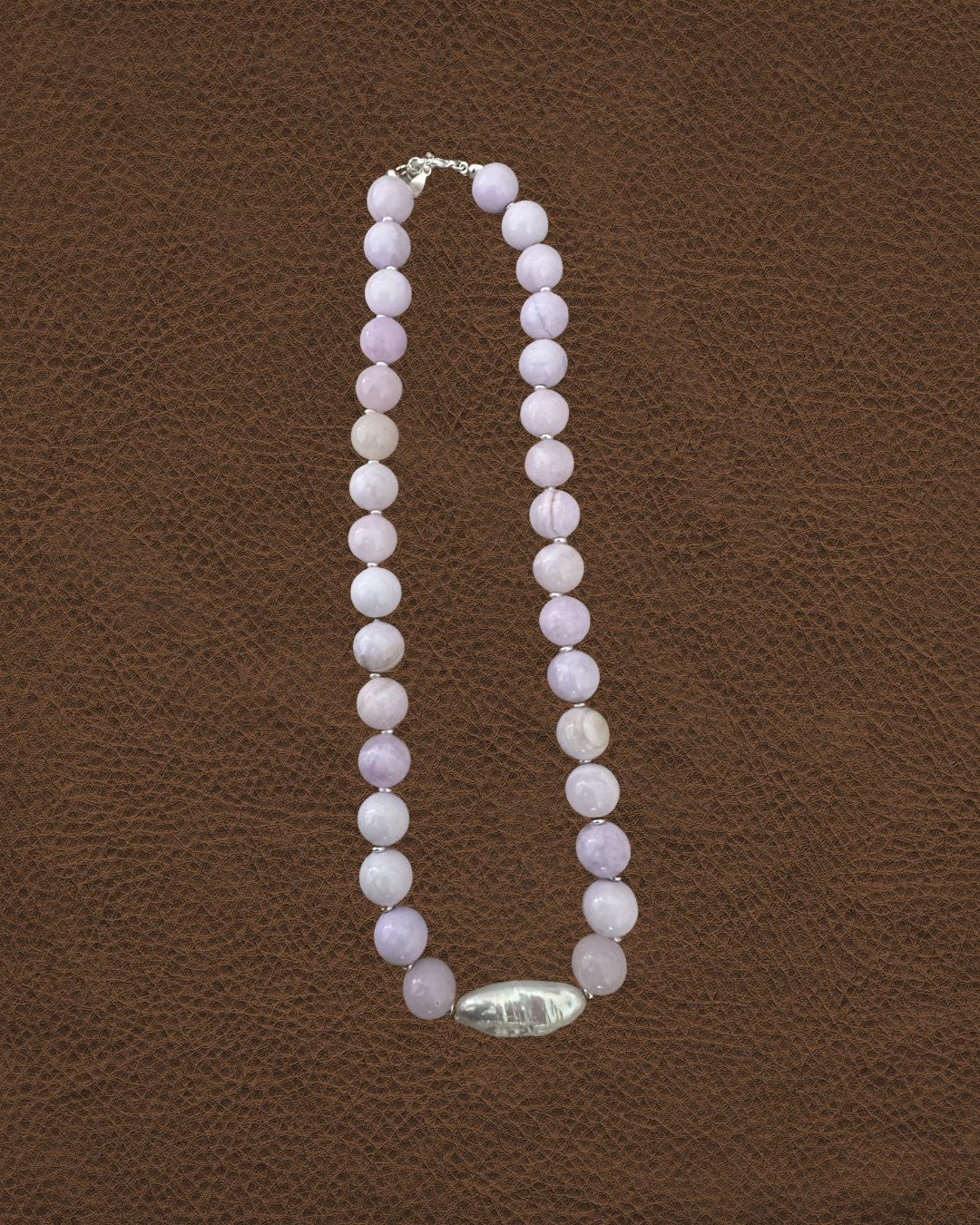 Necklace with pink beads on a brown textured background