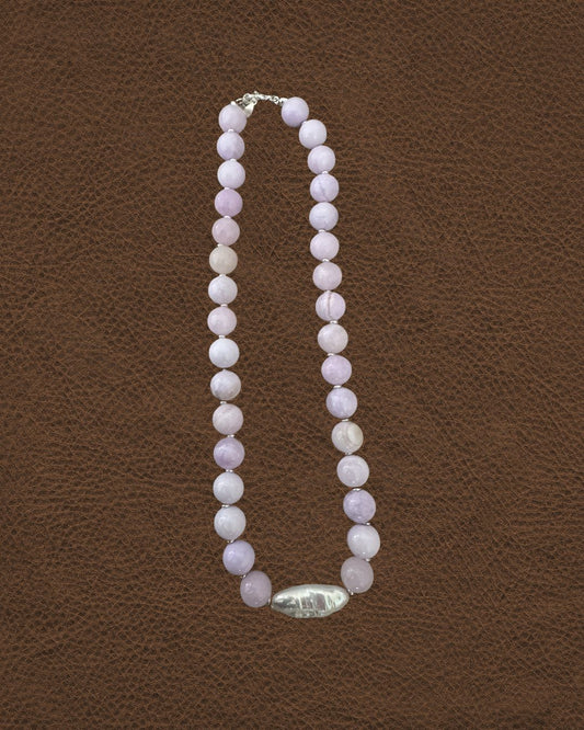 Necklace with pink beads on a brown textured background