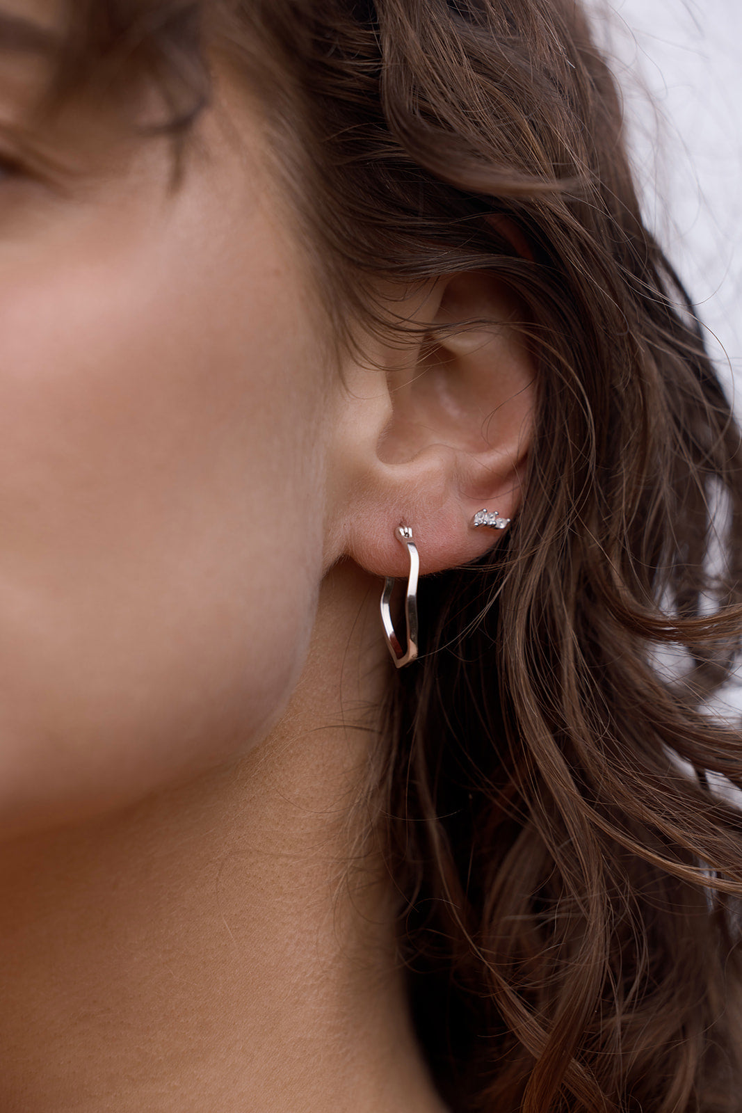 Lani Wave Hoops - Silver Close-up on an ear