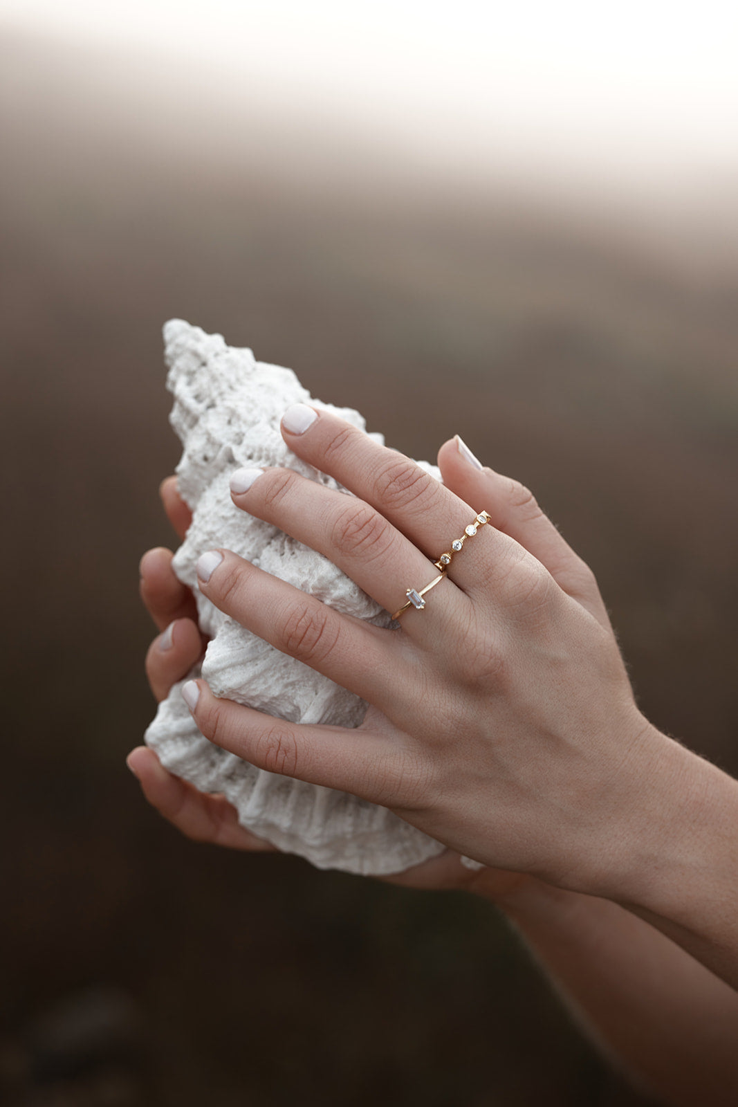 Lenni Crystal Ring on womens hand holding a shell