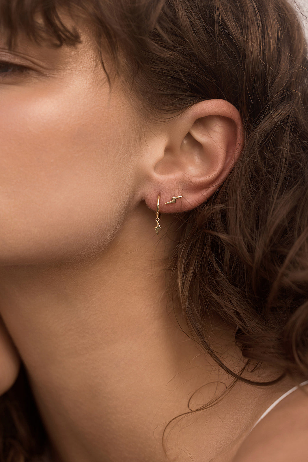 Lightning Bolt Studs - Gold close up on a women's ear