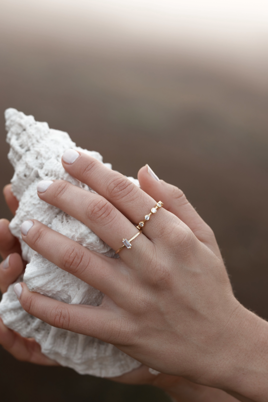 Luna Crystal Ring - Gold on womens hand holding a shell