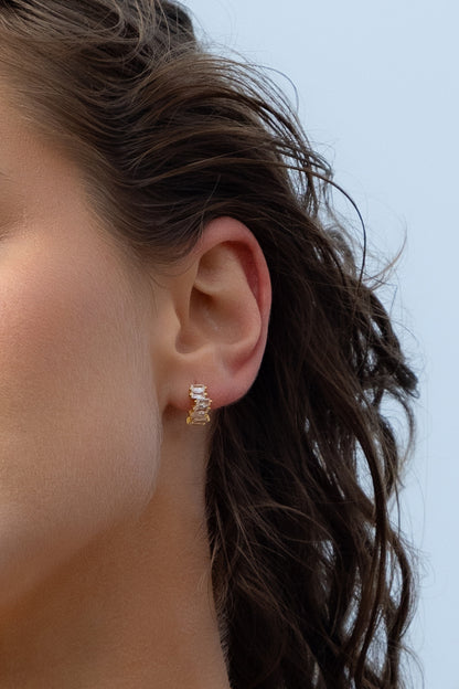 Close-up of Natasha Diamond Huggies earrings on a women