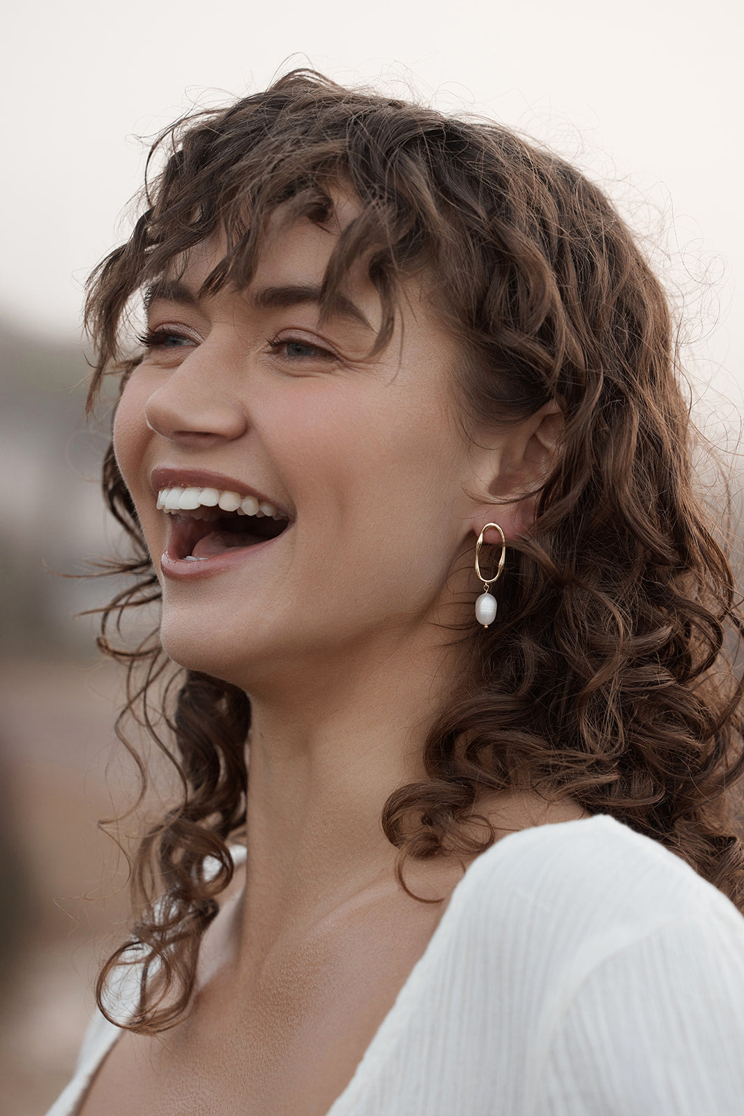 Nola Drop Pearl Earrings on womans ear