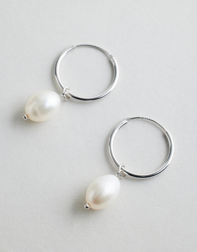 Oakley Pearl Hoops - Silver hoop earrings with pearls on a light gray background