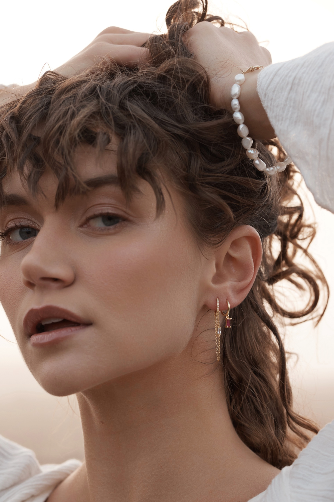 Close-up of a woman wearing the Phoebe Chain Huggies - Gold