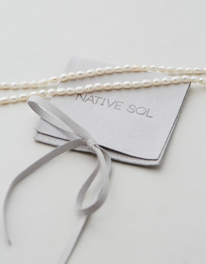 Poppy Pearl Choker flat lay necklace on jewellery branded pouch