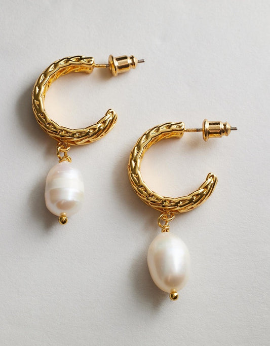 Romey Pearl hoop earrings with pearl drops on a light gray background