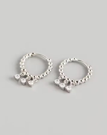 Sage Huggies - Silver hoop earrings with three dangle diamante stones each side, displayed against a white background.