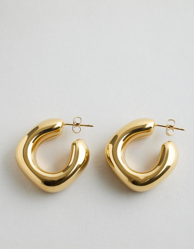 Sally Chunky Hoop Earrings - Gold on a white background.