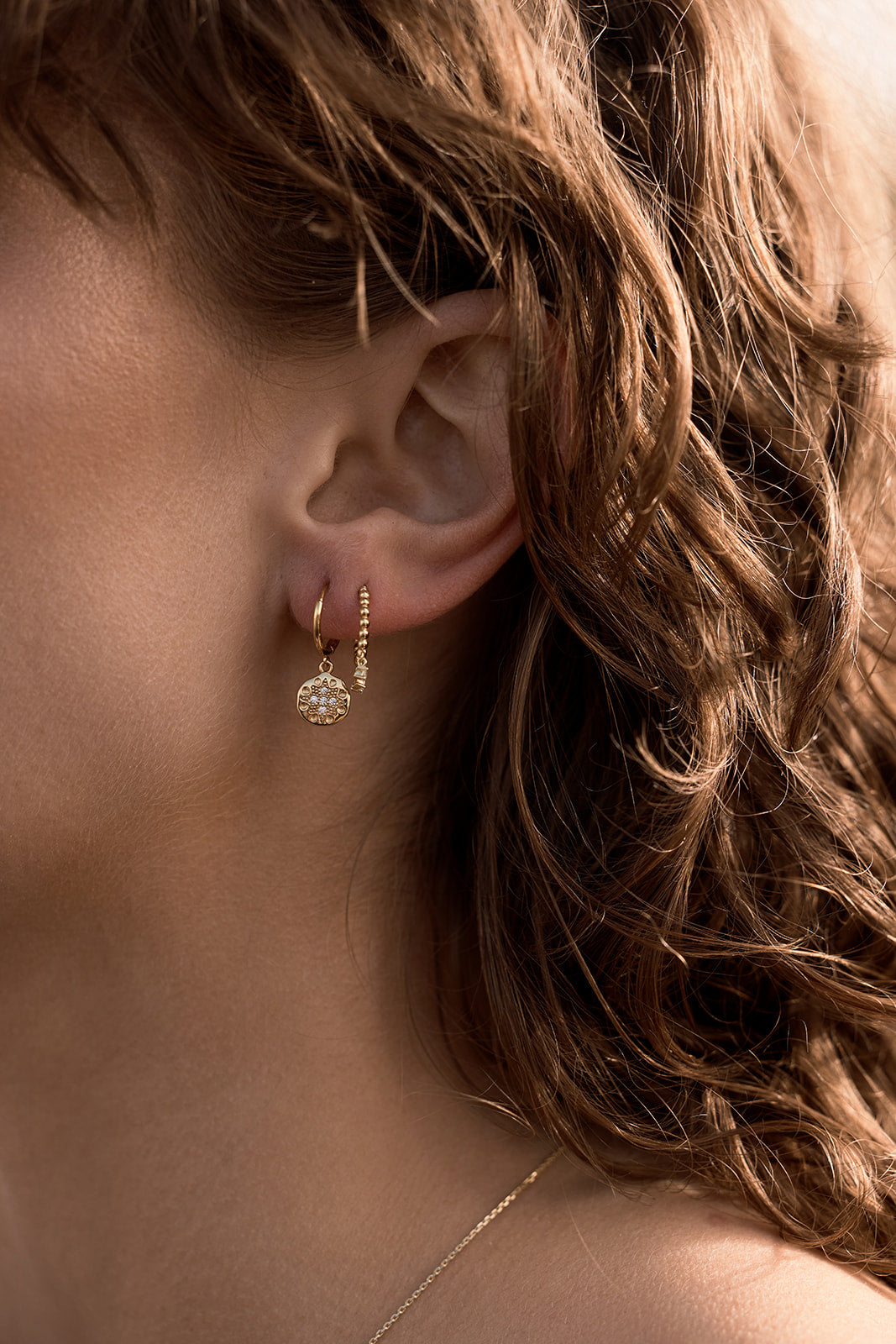 Seraphis Huggie Earrings - Gold on model close up