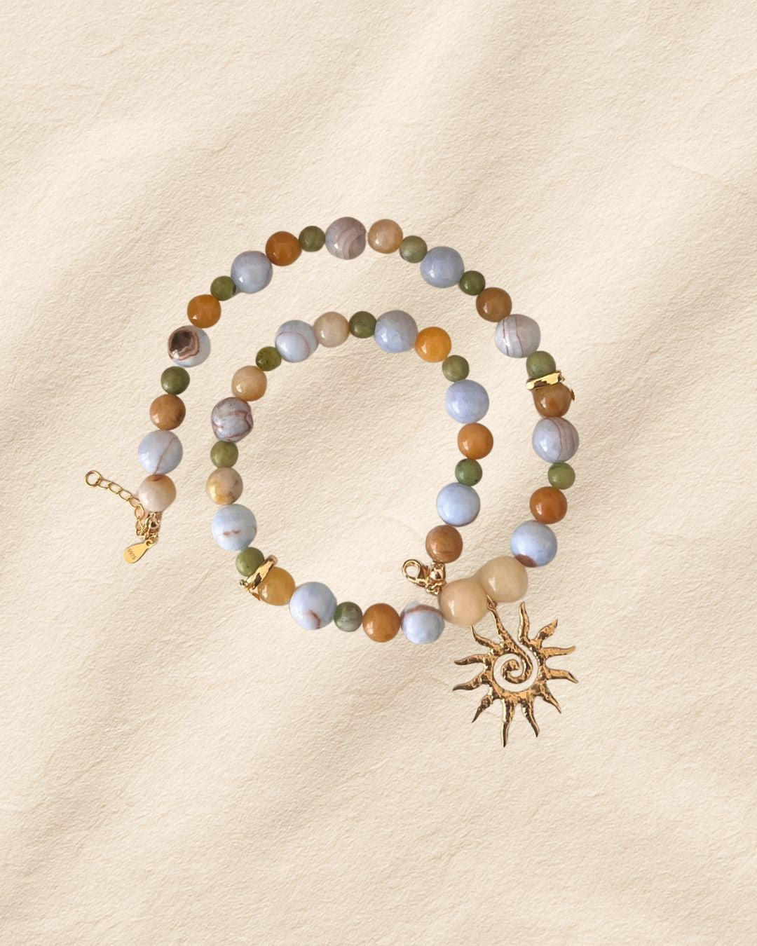 Beaded bracelet with sun charm on a beige background