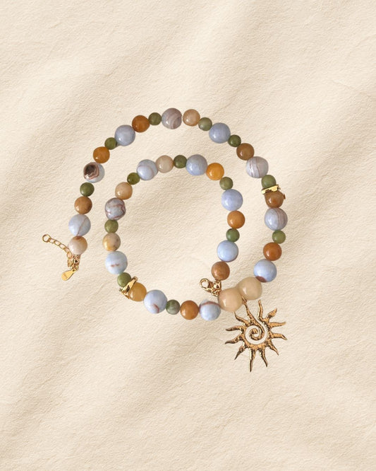 Beaded bracelet with sun charm on a beige background