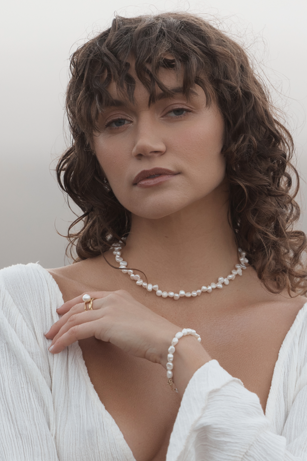 Woman wearing a Sophia Pearl Bracelet against a plain background