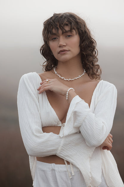 Sophia Pearl Bracelet Woman wearing a white outfit with a blurred background