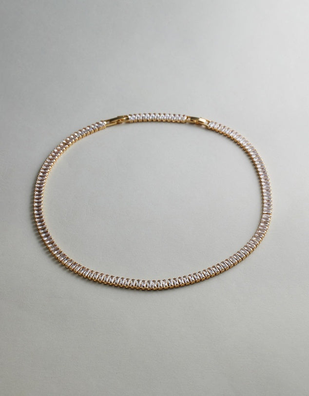 Gold Tennis Necklace on a light gray background