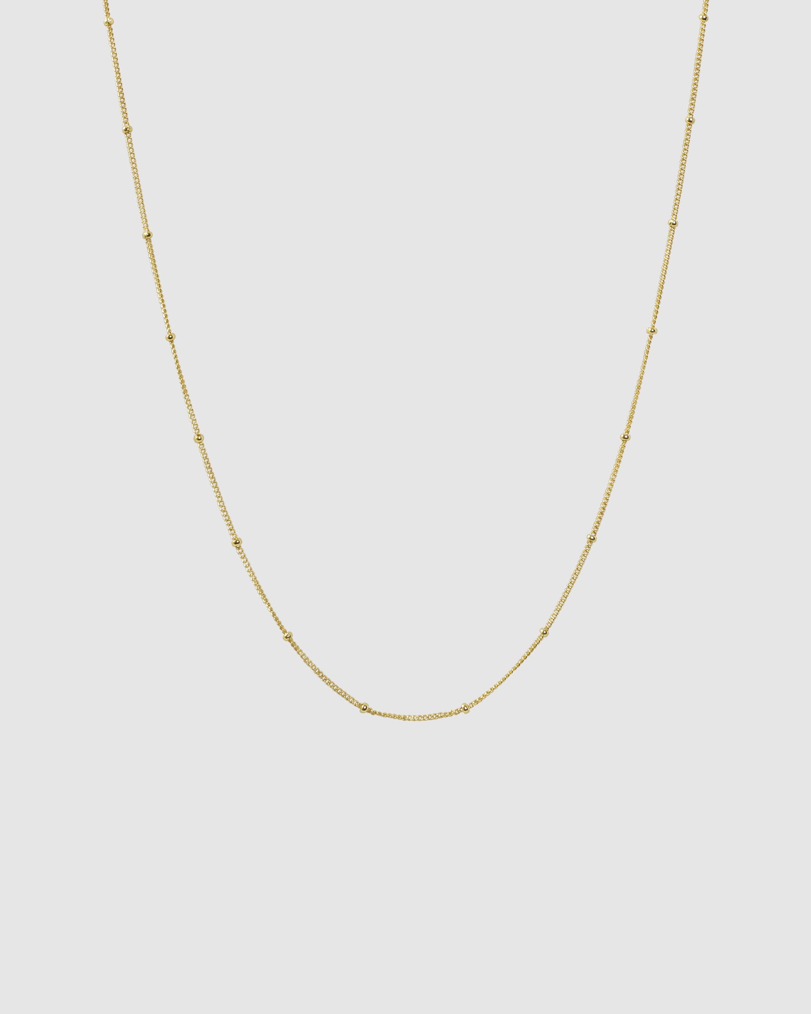 Gold Dot Chain necklace on a plain background.