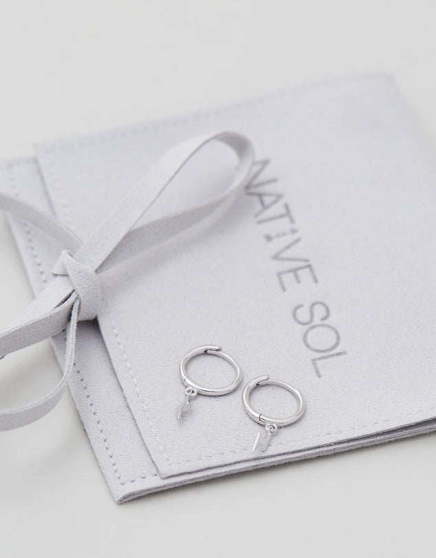 Lightning Bolt Huggies - Silver flat lay on jewellery pouch