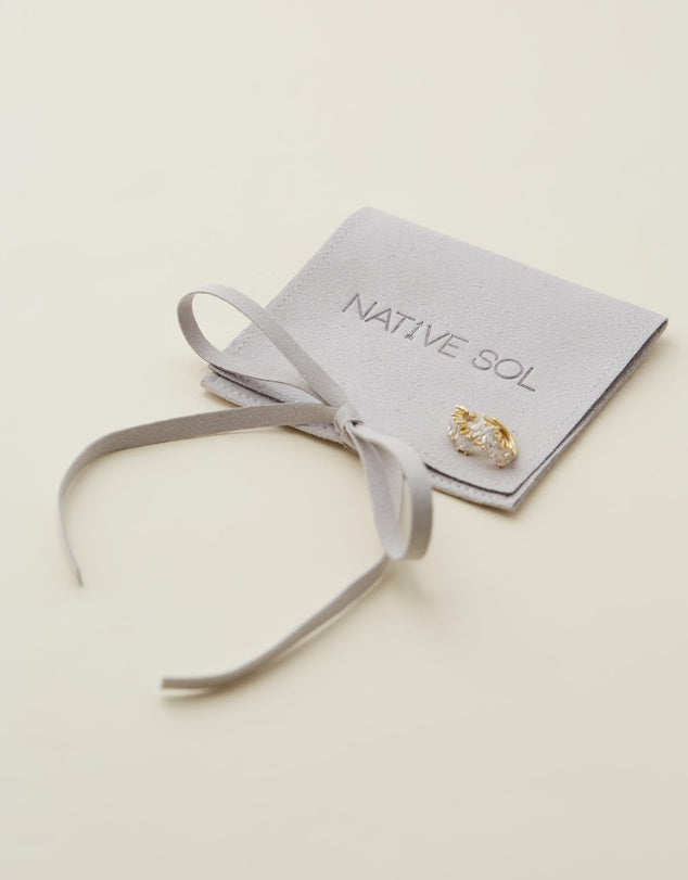 Natasha Diamond Huggies sitting on branded jewellery pouch