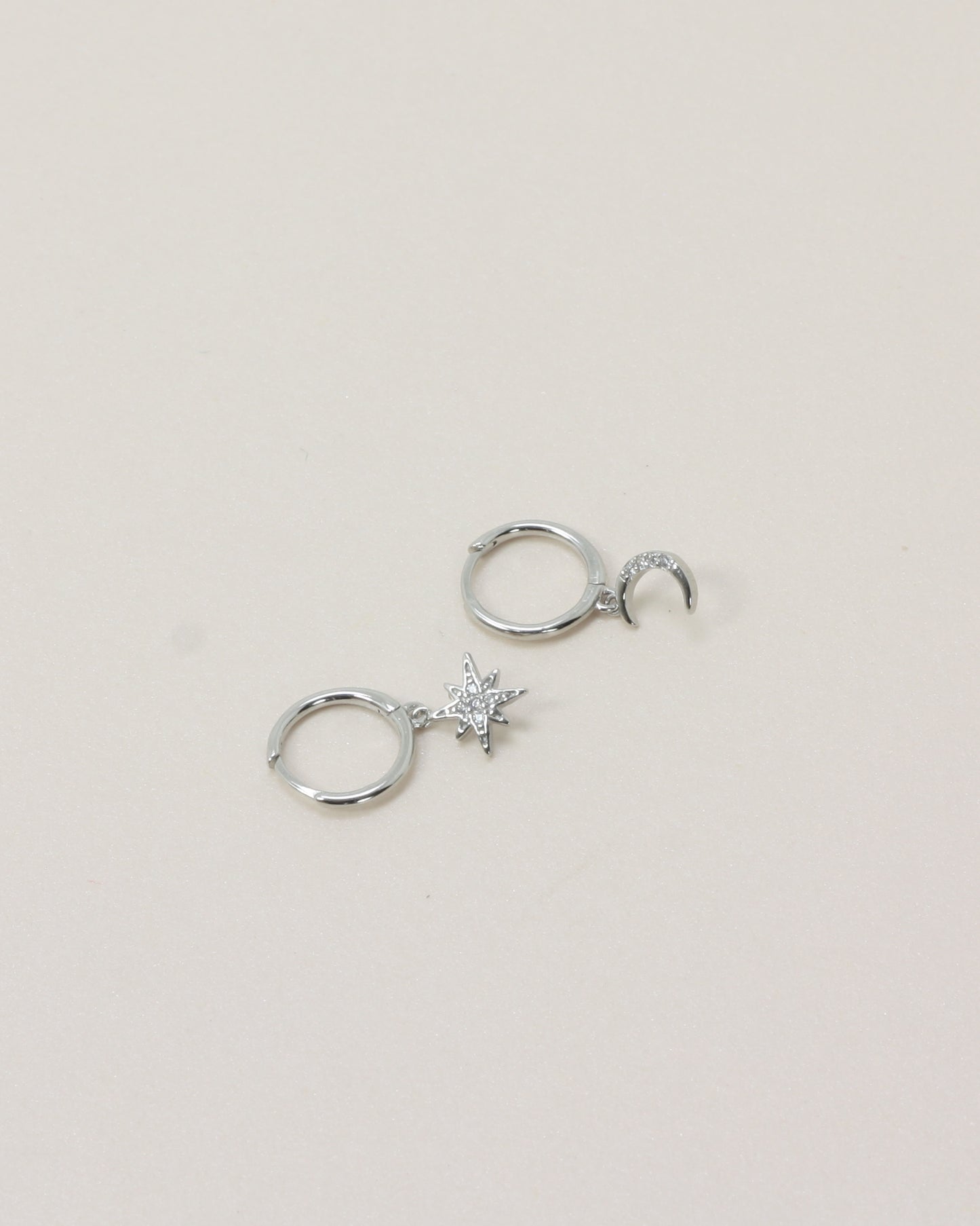 Night Sky Huggies - Silver flat lay on beige background