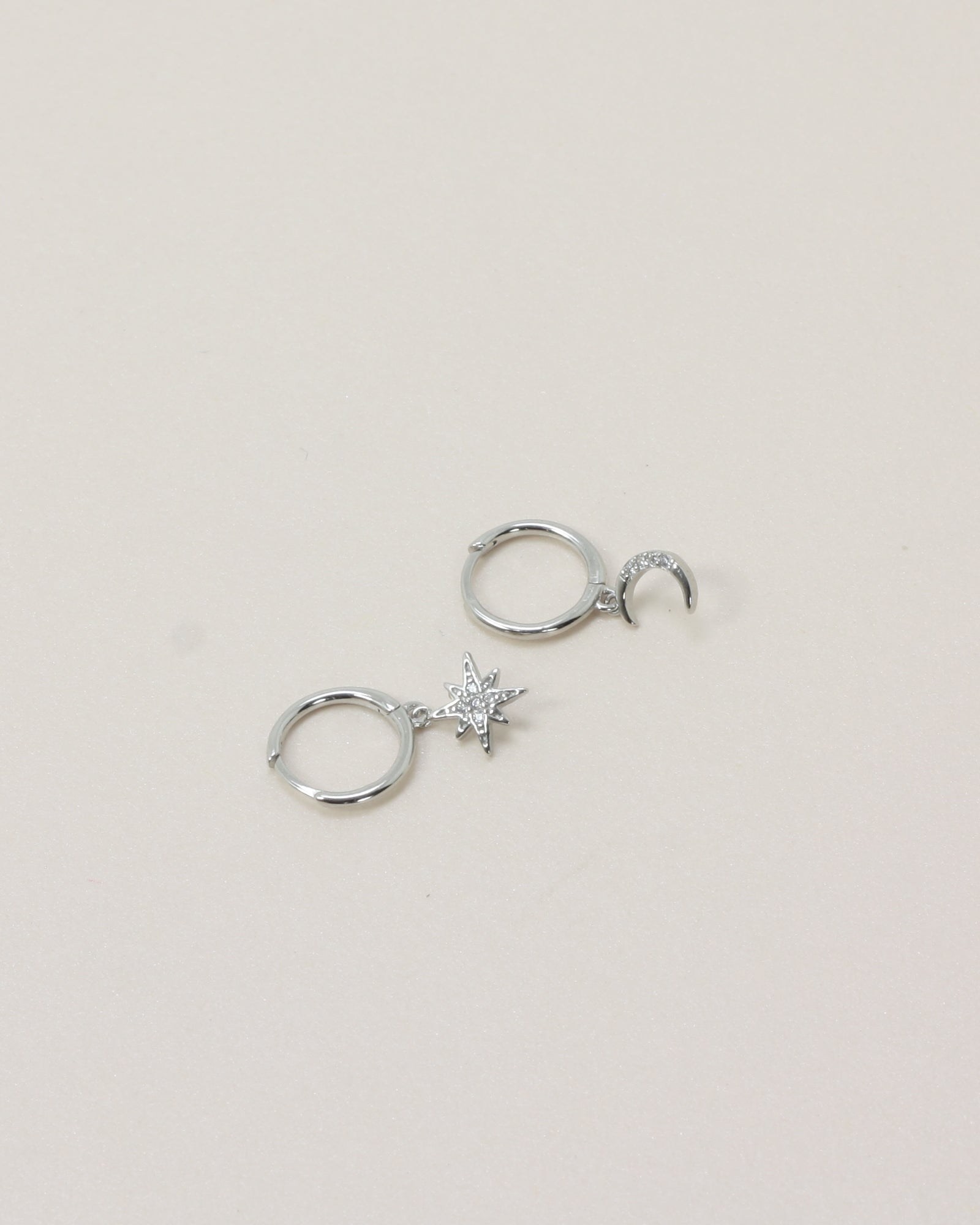 Night Sky Huggies - Silver flat lay on beige background