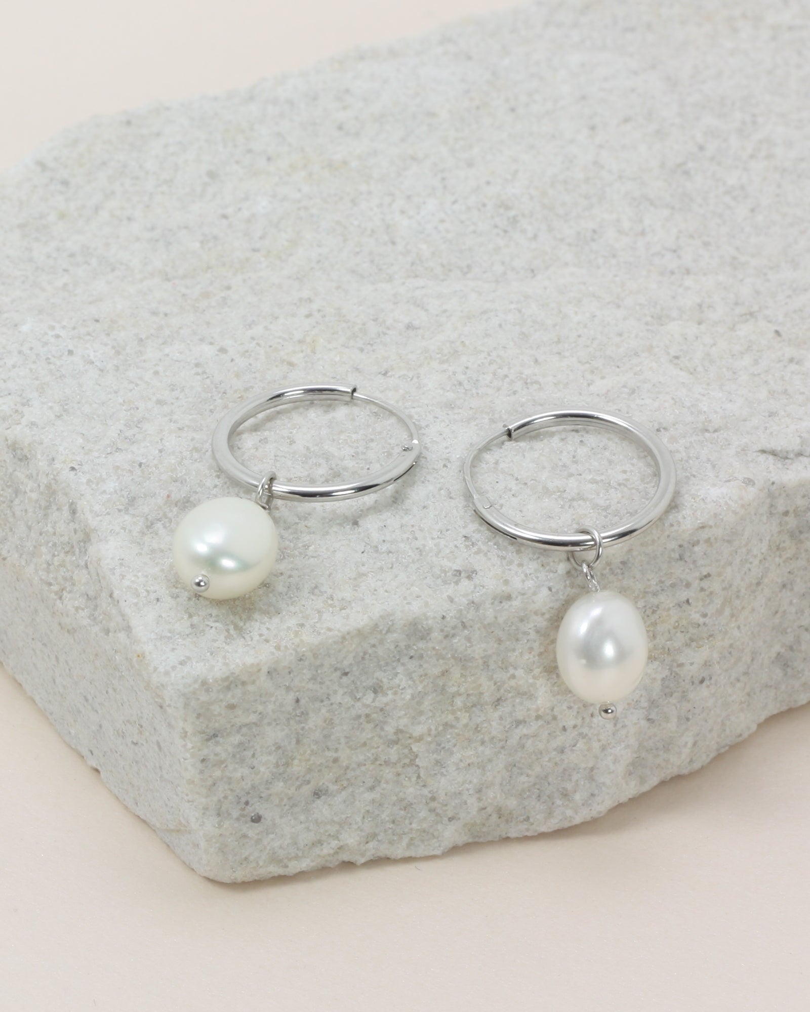 Oakley Pearl Hoops - Silver close up flat lay