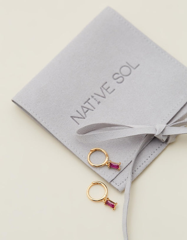 Rita Huggies - Pink & Gold laid out on branded jewellery pouch