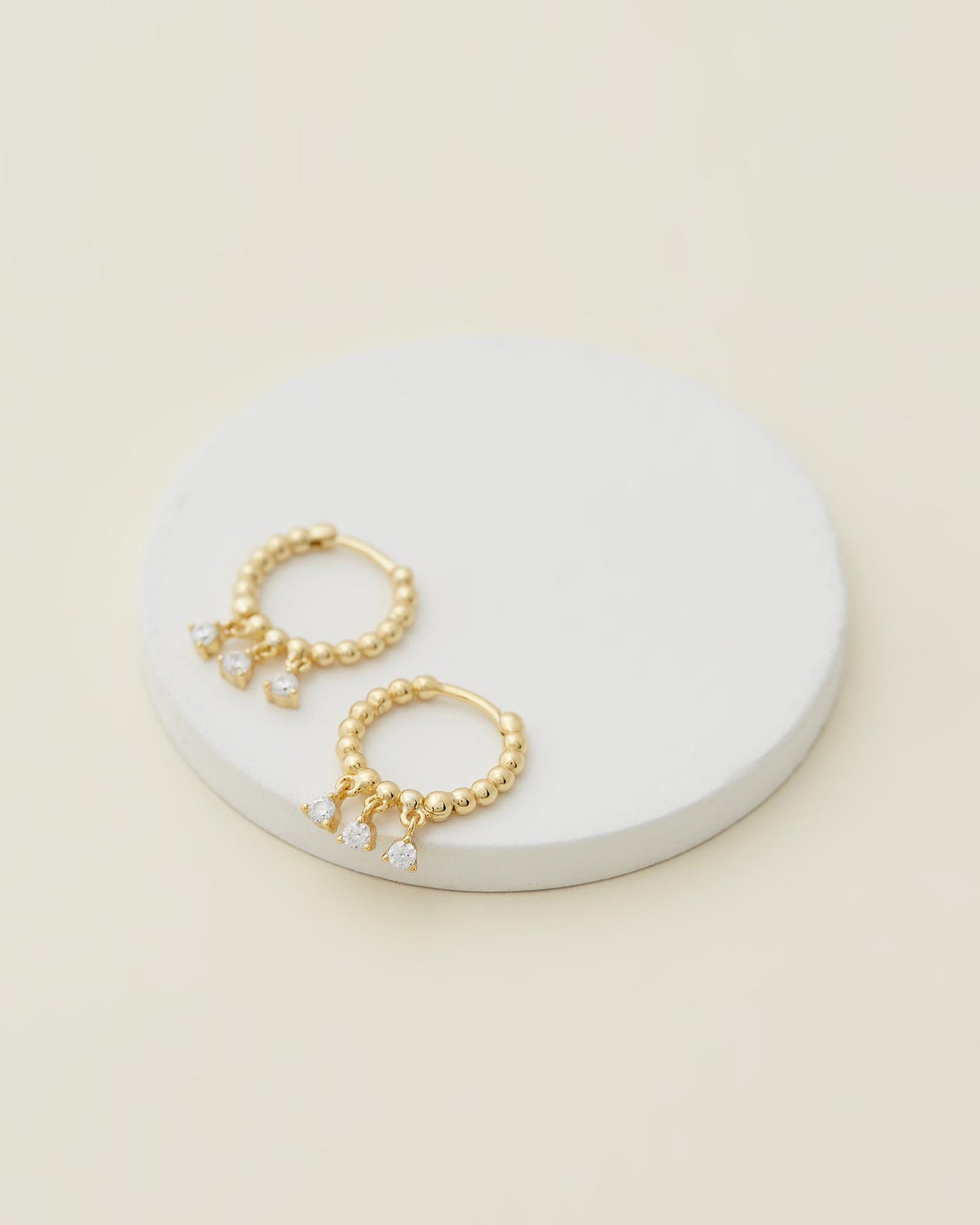 Sage Huggies - Gold close up on white disc