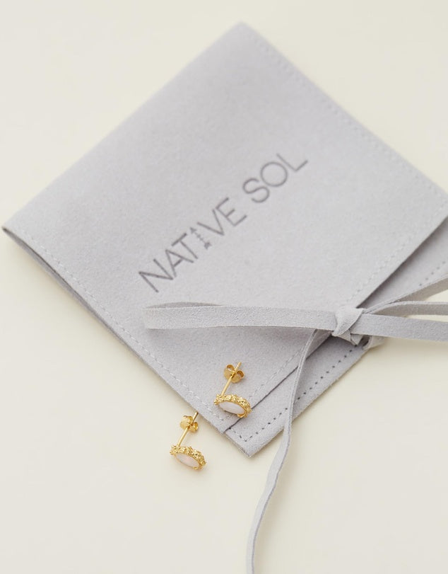 Simone Opal Studs - Gold laid out on grey jewellery pouch